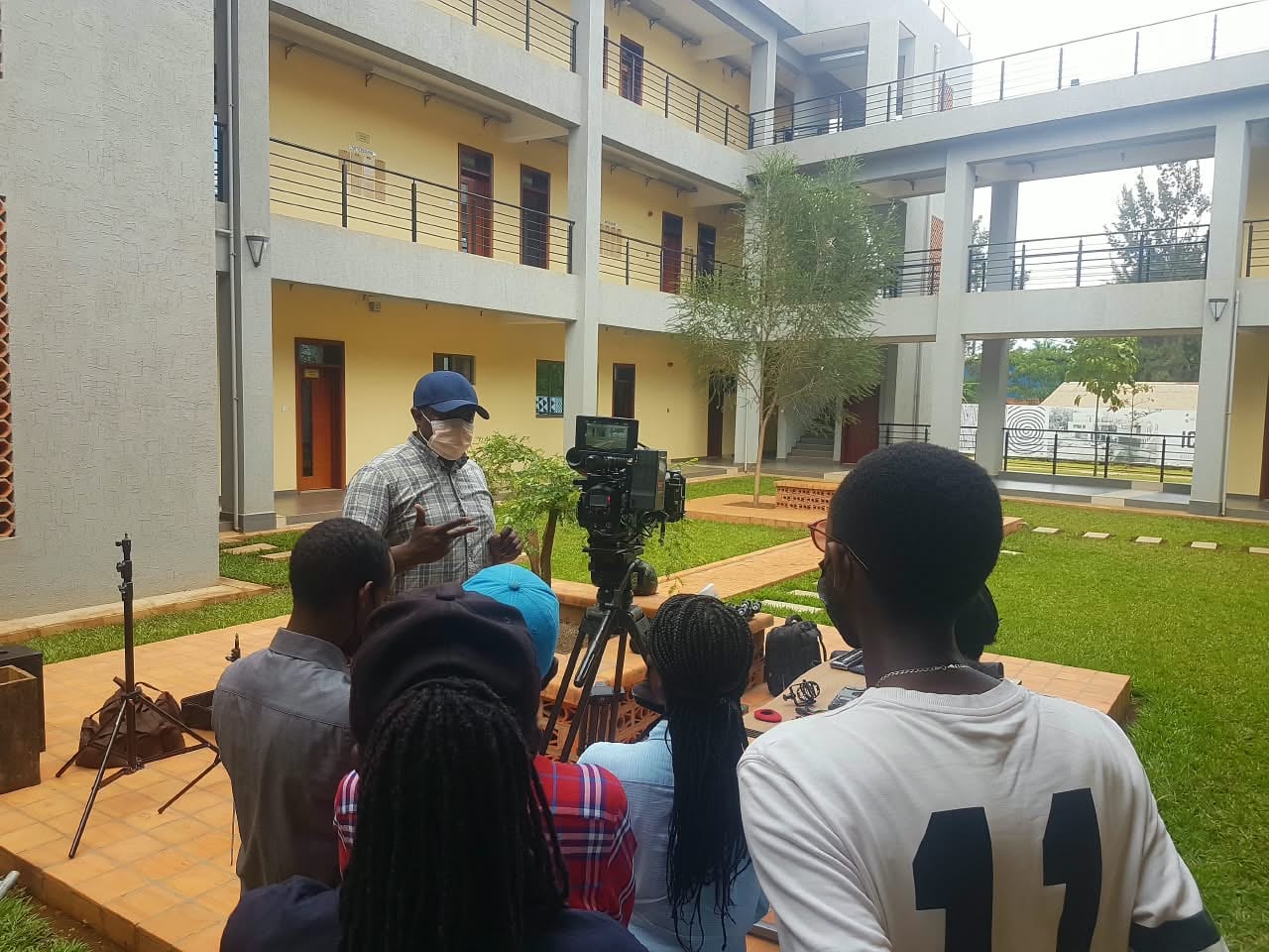 Young Rwandan creators actively collaborating during an outdoor cinema workshop in Kigali